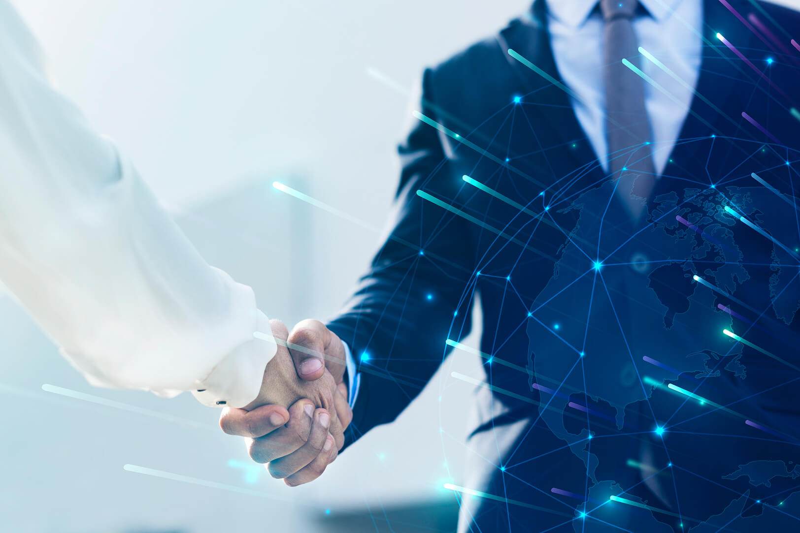 Dos personas dándose la mano en señal de acuerdo comercial, con fondo tecnológico y mapa del mundo